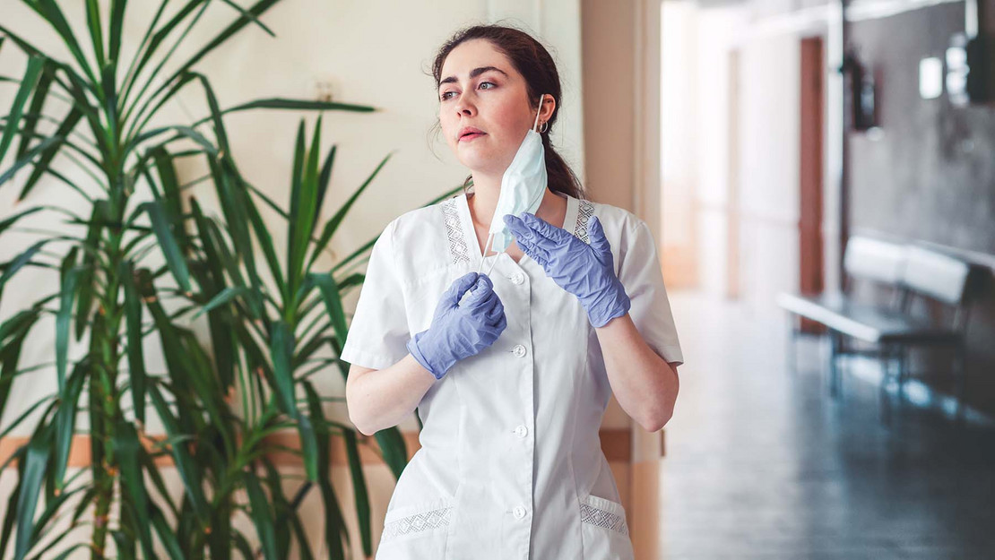 Erschöpfte Pflegekraft im Flur einer Einrichtung