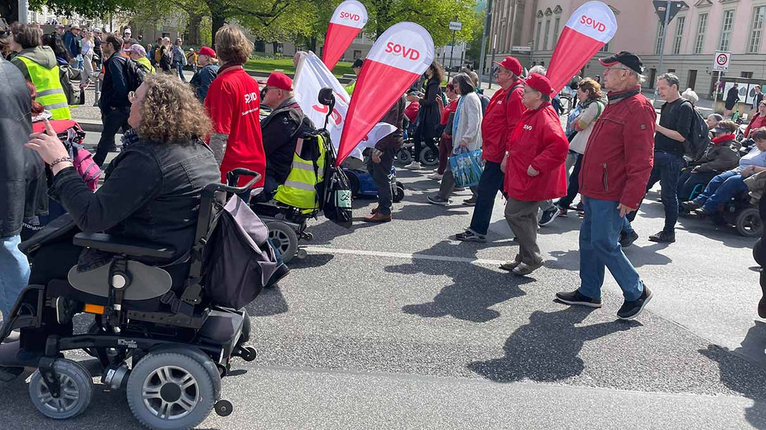 Menschengruppe mit SoVD-Wimpeln auf einer Demonstration. 