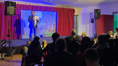 Mann spricht auf einer Bühne.