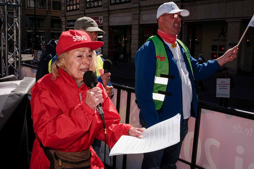 Frau mit Mikrofon steht auf der Ladefläche eines LKW und spricht. 