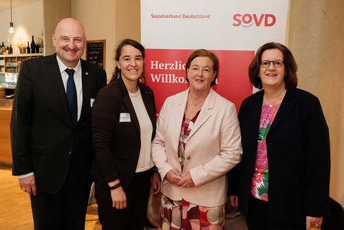 Vier Personen vor einem "Herzlich willkommen!"-Aufsteller des SoVD: Die SoVD-Vorstandsvorsitzende Michaela Engelmeier mit den SPD-Bundestagsabgeordneten Bernd Rützel, Heike Heubach und Kerstin Griese.