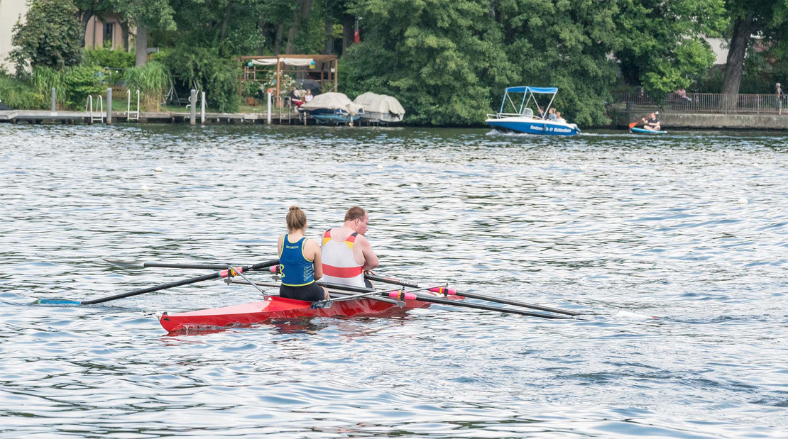 Zwei Menschen rudern auf einem Fluss