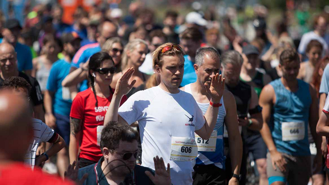 Menschengruppe in Sportkleidung macht gemeinsam Übungen.