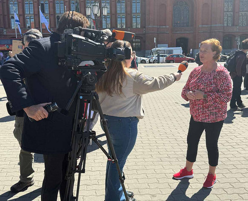 Eine Frau steht vor einer Fernsehkamera und spricht in ein ZDF-Mikrofon