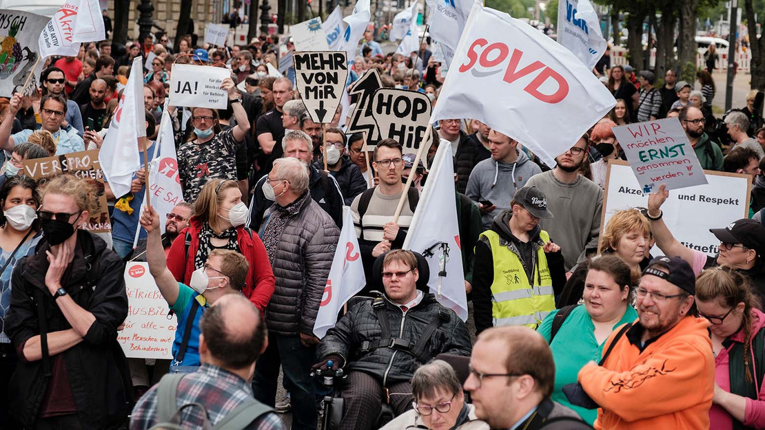 Bild einer Demonstration mit SoVD-Fahne im Vordergrund. 