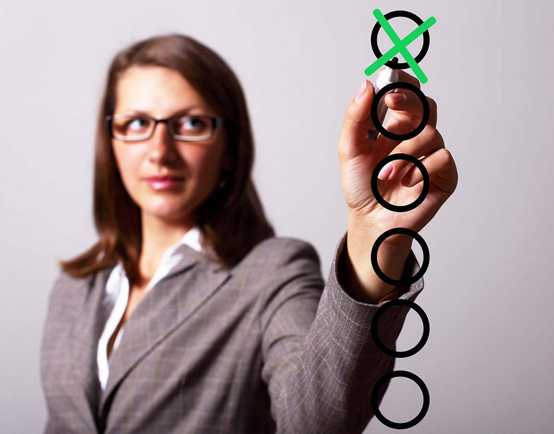 Frau kreuzt etwas an.