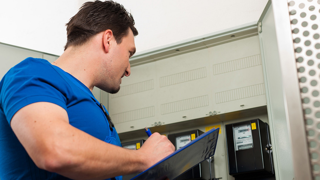 Ableser notiert Daten von Stromzähler Ableser notiert Daten von Stromzähler