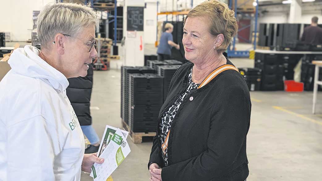 Zwei Frauen in einer Lagerhalle im Gespräch